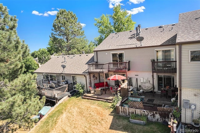 4541 W Ponds Cir, Littleton, CO 80123 - rear view of house featuring brick siding, a balcony, outdoor lounge area, a lawn, and a deck