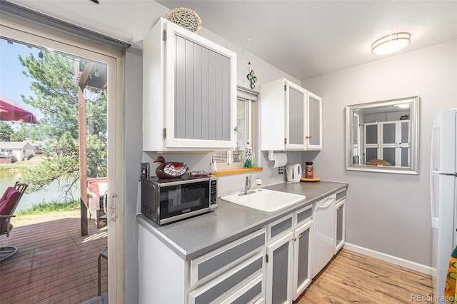 4541 W Ponds Cir, Littleton, CO 80123 - kitchen with white appliances, light wood-style floors, and white cabinets
