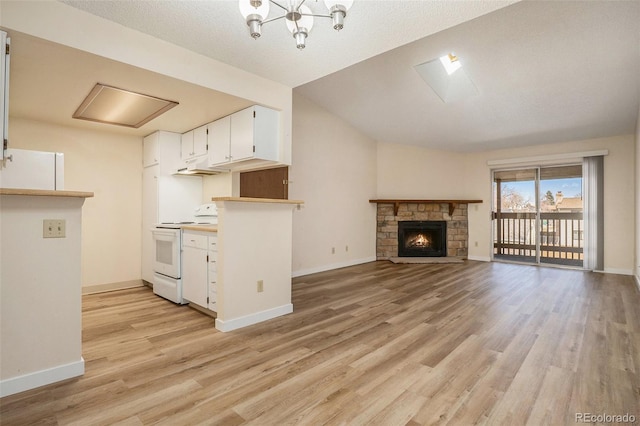 kitchen with baseboards, under cabinet range hood, light wood-style floors, white appliances, and white cabinetry