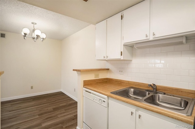 kitchen featuring a sink, white cabinets, white dishwasher, decorative backsplash, and a chandelier