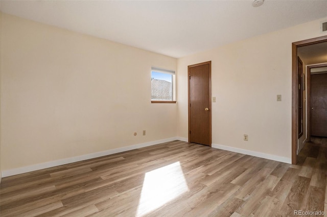 unfurnished room featuring visible vents, baseboards, and light wood-style flooring