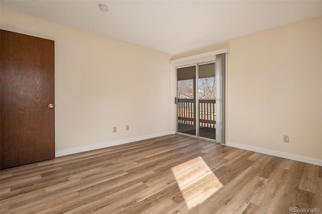 spare room featuring wood finished floors and baseboards