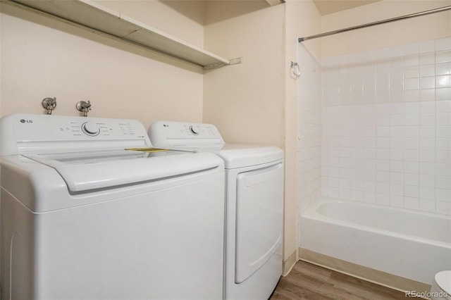 laundry room featuring washer and dryer, laundry area, and wood finished floors