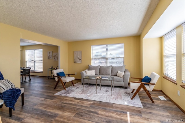 living room featuring dark wood-type flooring and a textured ceiling