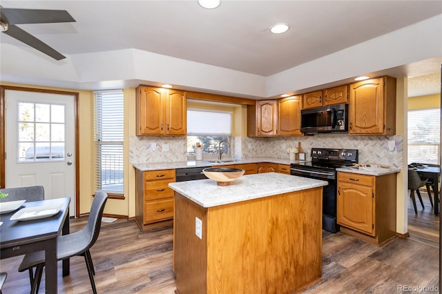 kitchen featuring a kitchen island, sink, ceiling fan, black appliances, and dark wood-type flooring