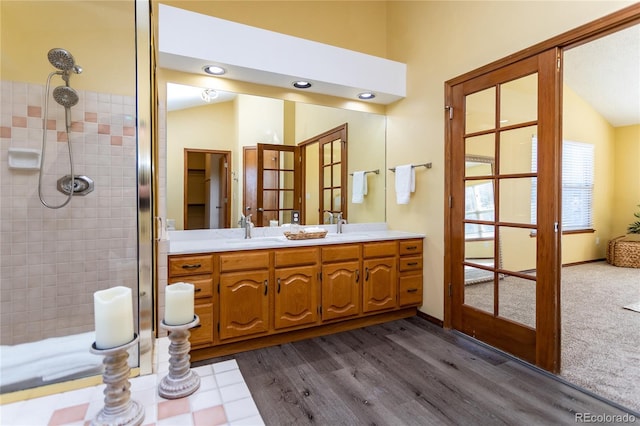 bathroom with lofted ceiling, vanity, wood-type flooring, french doors, and walk in shower