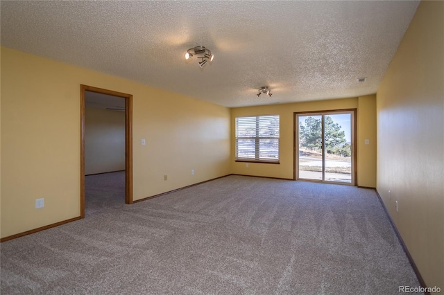 carpeted spare room featuring a textured ceiling