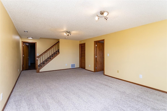 carpeted spare room featuring a textured ceiling