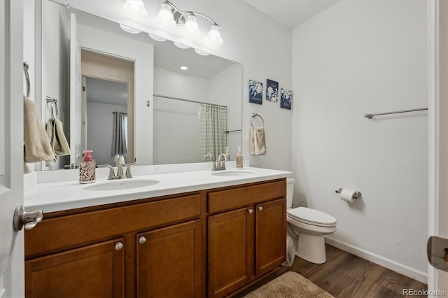27957 E 9th Dr, Aurora, CO 80018 - full bath featuring wood finished floors, toilet, baseboards, double vanity, and a shower with curtain