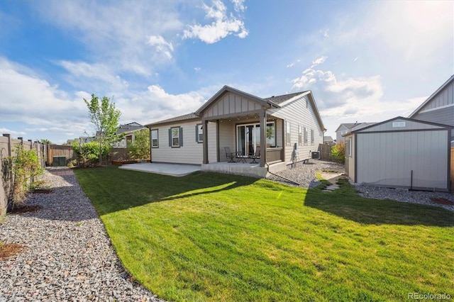 27957 E 9th Dr, Aurora, CO 80018 - back of property with board and batten siding, a storage shed, a patio, and an outbuilding