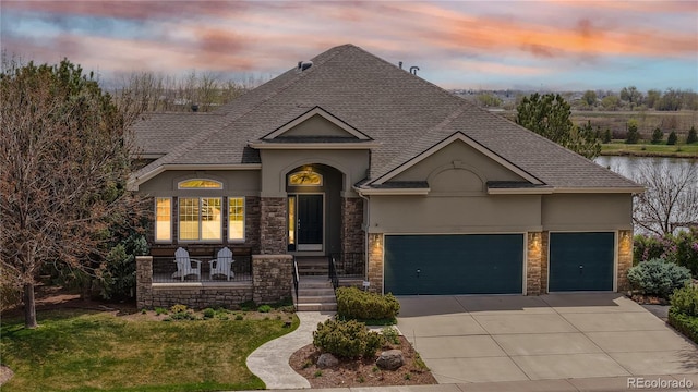 view of front of house with a garage, stucco siding, driveway, and stone siding