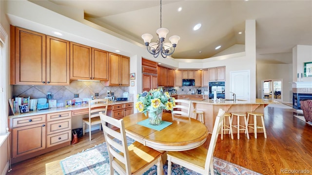 dining area with recessed lighting, a notable chandelier, vaulted ceiling, and light wood-style floors