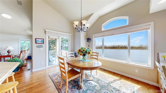 dining area with visible vents, light wood finished floors, baseboards, and a chandelier