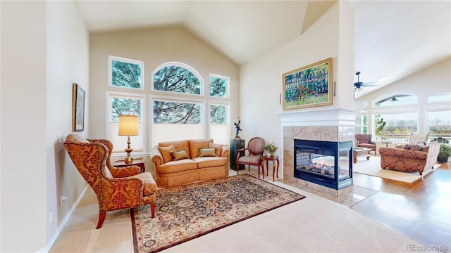 interior space featuring high vaulted ceiling, a tiled fireplace, and ceiling fan