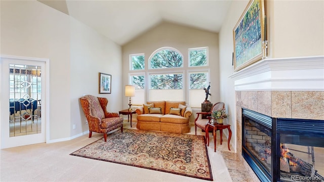 sitting room featuring plenty of natural light, carpet, a tiled fireplace, and high vaulted ceiling