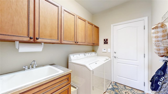 washroom featuring a sink, cabinet space, and washing machine and clothes dryer