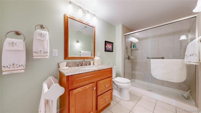 bathroom featuring toilet, tile patterned floors, a shower stall, and vanity