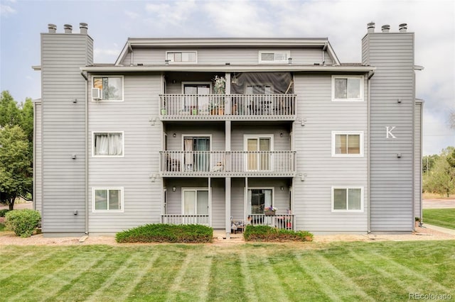 8100 W Quincy Ave Unit K3, Littleton, CO 80123 - back of house with a balcony, a chimney, and a lawn
