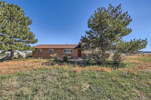 back of property with brick siding and fence