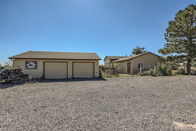 exterior space featuring fence, an outdoor structure, and a garage