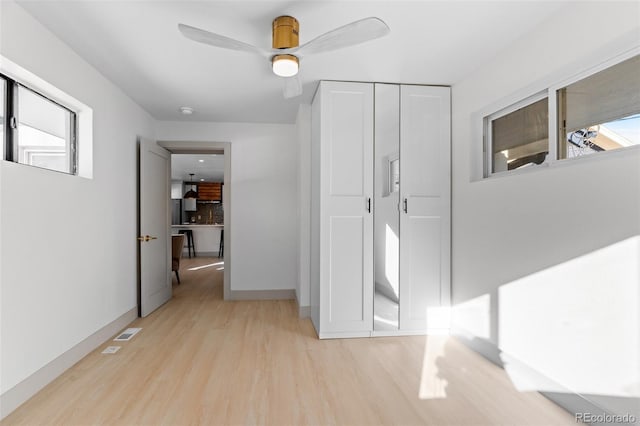 hall featuring a wealth of natural light and light hardwood / wood-style flooring