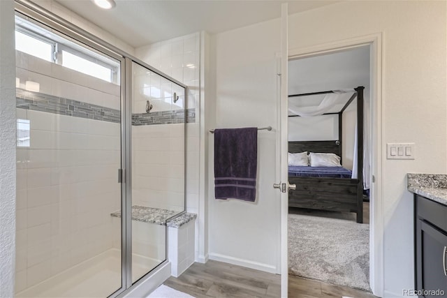 bathroom featuring hardwood / wood-style floors, a shower with shower door, and vanity