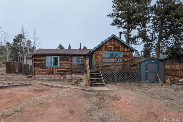 back of house featuring a deck and a storage unit