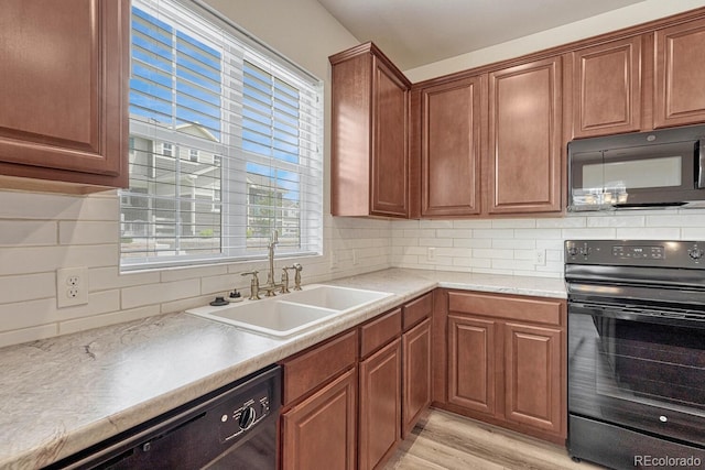 kitchen with light hardwood / wood-style flooring, black appliances, tasteful backsplash, and sink