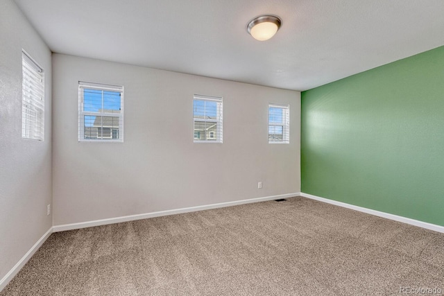 carpeted empty room with plenty of natural light