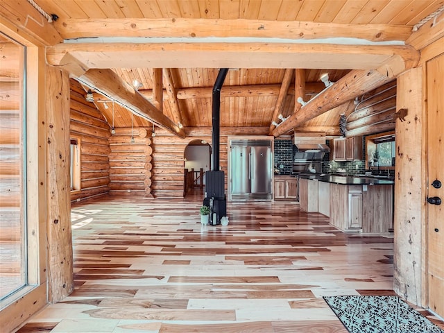 interior space featuring vaulted ceiling with beams, wooden ceiling, and light hardwood / wood-style flooring