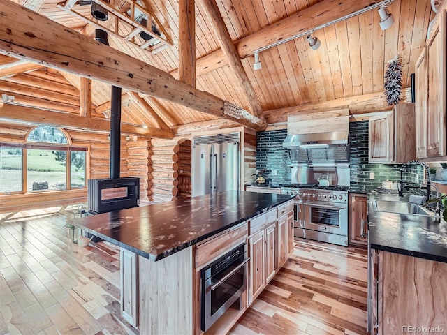 kitchen featuring sink, a center island, lofted ceiling with beams, a wood stove, and premium appliances