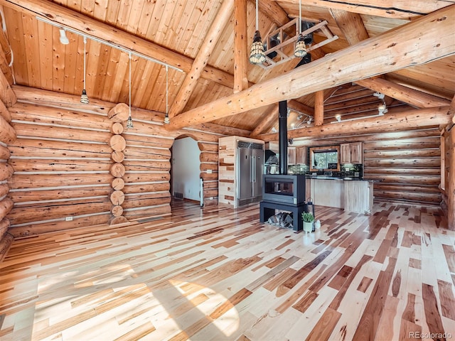 unfurnished living room with wood ceiling, light hardwood / wood-style floors, beamed ceiling, and a wood stove