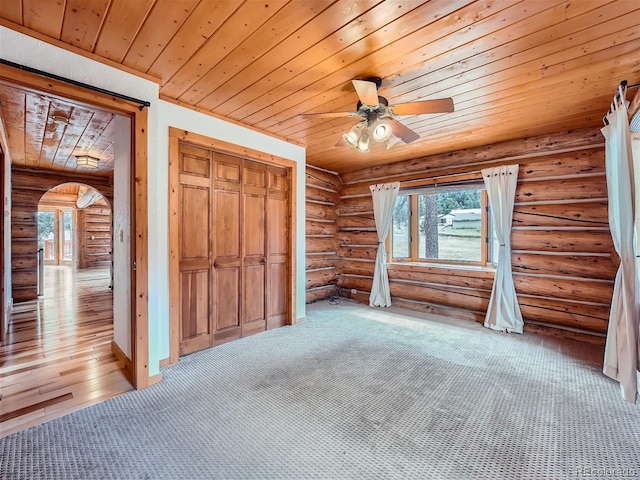 unfurnished bedroom featuring light carpet, wood ceiling, a closet, and ceiling fan