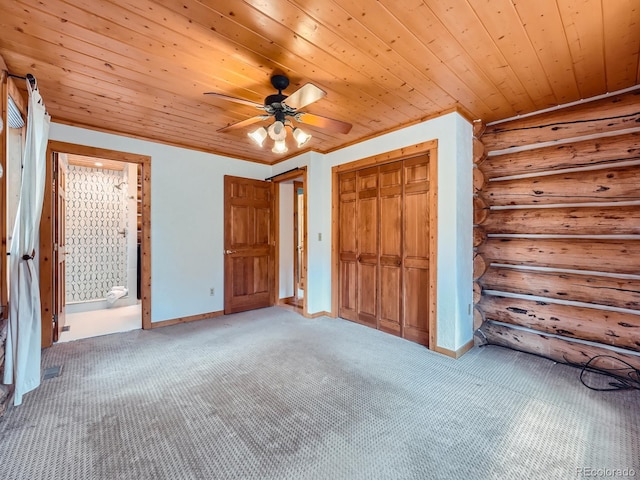 unfurnished bedroom featuring rustic walls, wooden ceiling, a closet, ceiling fan, and carpet