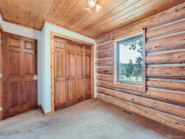 unfurnished bedroom with light carpet, rustic walls, wood ceiling, and a closet