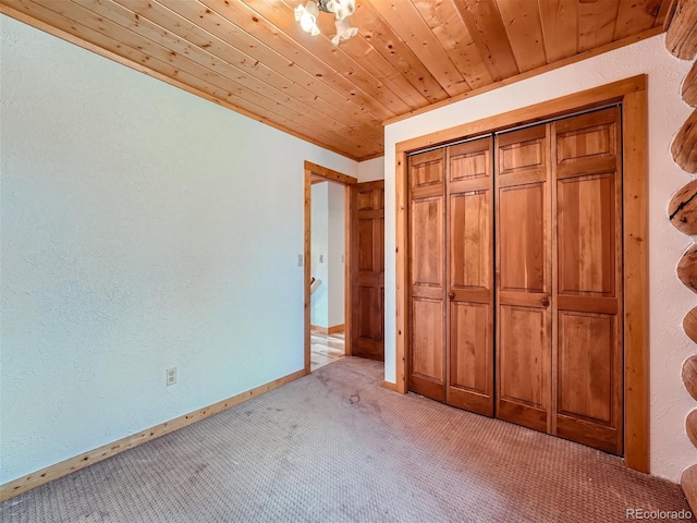 unfurnished bedroom featuring a closet, light carpet, and wooden ceiling