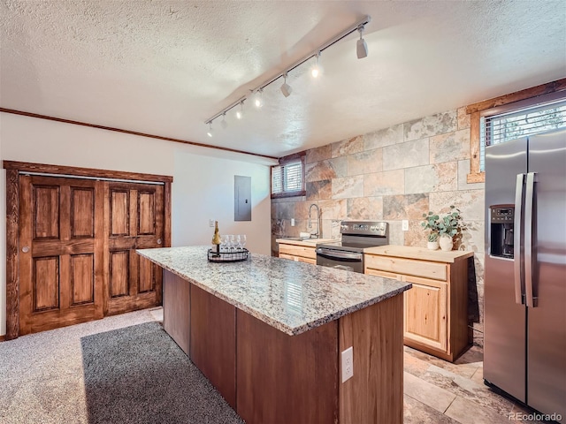 kitchen featuring stainless steel appliances, a center island, a textured ceiling, and electric panel