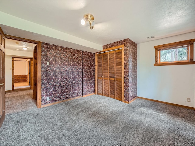 unfurnished bedroom with a closet, a textured ceiling, and carpet flooring