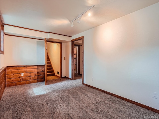 carpeted empty room featuring track lighting