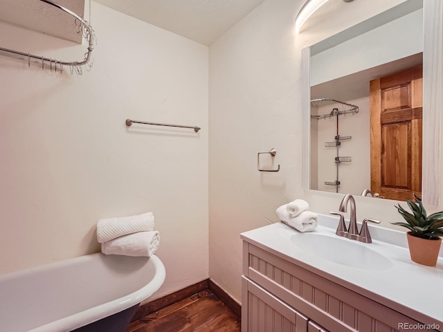 bathroom featuring vanity, hardwood / wood-style floors, and a washtub