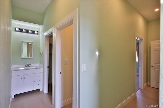 corridor featuring sink and hardwood / wood-style flooring
