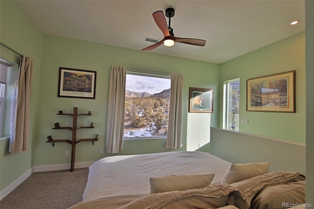 bedroom with ceiling fan, a mountain view, and light carpet