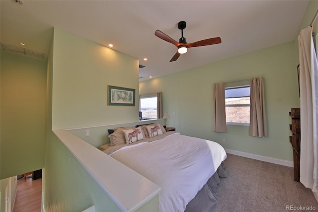 carpeted bedroom with multiple windows and ceiling fan
