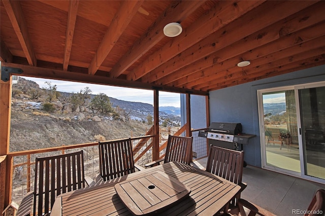wooden deck with a mountain view and area for grilling