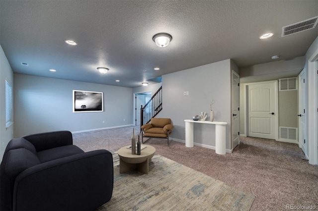 living area featuring a textured ceiling and carpet flooring