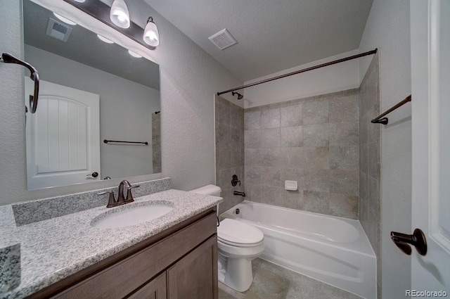 full bathroom with vanity, toilet, a textured ceiling, and tiled shower / bath