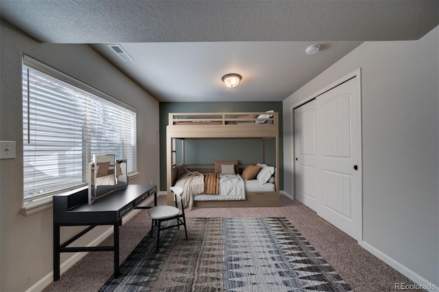 carpeted bedroom featuring a closet and a textured ceiling