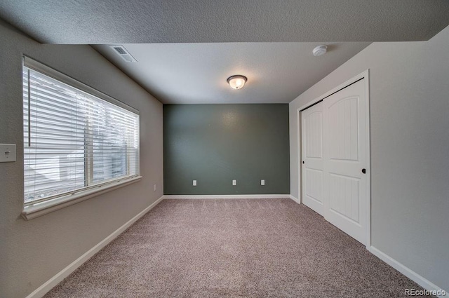 unfurnished bedroom featuring carpet flooring and a textured ceiling