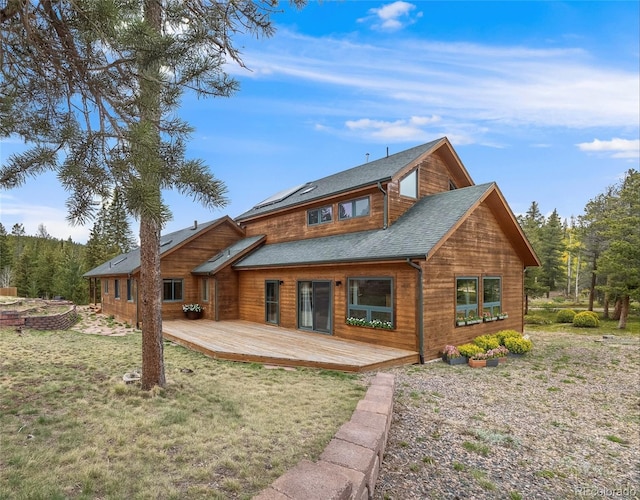 1002 County Road 99, Black Hawk, CO 80422 - rear view of house with a lawn, a deck, roof mounted solar panels, and roof with shingles