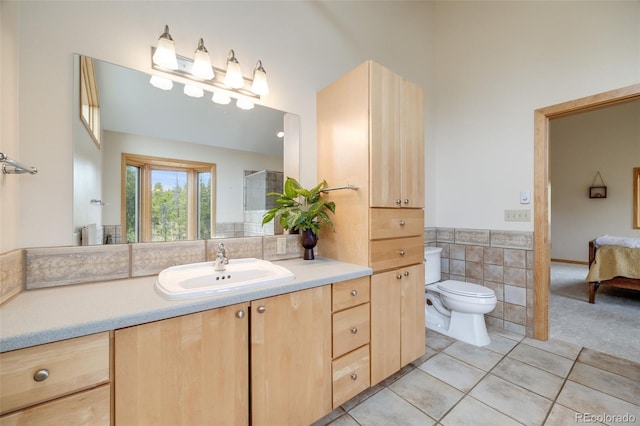 1002 County Road 99, Black Hawk, CO 80422 - ensuite bathroom featuring toilet, tile patterned floors, vanity, and tile walls